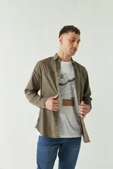 Camisa de gabardina gris con corte slim, mangas largas, cartera abotonada y dos bolsillos con solapa en el pecho.
