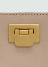 Bolso tipo bucket negro con asa corta y cierre metálico dorado.