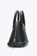 Bolso de mano color negro, con detalles metálicos dorados, bolsillo interior con cierre y correa extraíble para usar como bandolera.