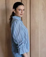 Blusa celeste con cuello mao y mangas abullonadas.