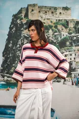 Remera de algodón y poliéster a rayas horizontales rosas, azul marino y rojo, con cuello tipo polo marrón y botones. Corte oversized con caída relajada y mangas amplias.