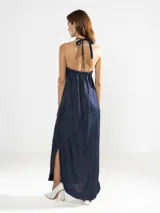 Vestido largo blanco de lino italiano con hilo metalizado y escote halter ajustable con cordón.