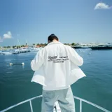 Camisa blanca de manga corta con cuello tipo cubano, corte oversize y estampado con el logo de la marca en el pecho y la espalda.