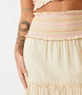 Conjunto de top corto con breteles finos y pollera midi de algodón color crema con cintura elastizada y volados en el ruedo.