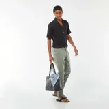 Camisa negra de manga corta con cuello solapa y cierre frontal con botones de madera.