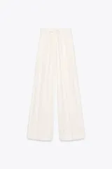 Pantalón palazzo color crudo, confeccionado en hilatura con mezcla de lyocell. Tiro medio, cintura elástica ajustable con cordones, bolsillos laterales ocultos en costura y pierna ancha.