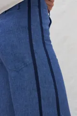 Pantalón de lino azul con corte jeanero, bolsillos plaque en la trasera y cintas laterales a contratono.