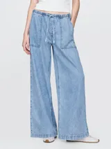 Pantalón de jean celeste claro, corte amplio, con cintura elástica ajustable con cordón, bolsillos laterales y traseros.