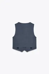 Chaleco negro con escote en pico, sin mangas y cierre frontal con botones.