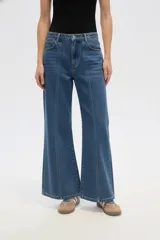 Pantalón de jean blanco de tiro alto, con corte acampanado (flare) y costuras verticales marcadas en el frente de ambas piernas.