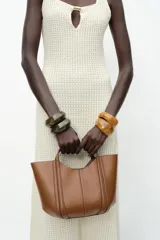 Bolso mini city color marrón con asa de mano y asa bandolera extraíble. Incluye bolsa interior extraíble con cierre mediante cremallera.