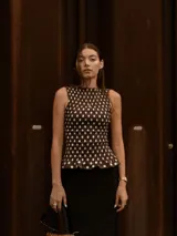 Top marrón con lunares blancos, sin mangas y con detalle de frunces en el cuerpo.