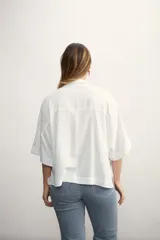 Blusa negra de lino con cuello polo y mangas cortas amplias.