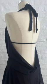 Vestido corto negro con escote halter y espalda descubierta.