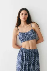 Pollera larga de algodón con estampado floral blanco sobre fondo azul, corte holgado, tiro alto y cintura elástica. Forrada.