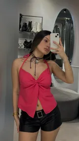 Top fucsia con escote halter y detalle de nudo en el frente.