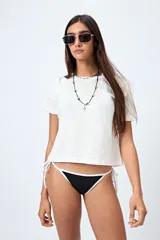Bottom de bikini negro con tiras ajustables a los costados y bordes blancos en contraste.
