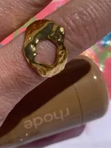Anillo dorado de acero inoxidable con forma irregular y abertura central.