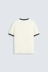 Camiseta azul marino de corte regular, cuello redondo y manga corta con ribete blanco en cuello y mangas.