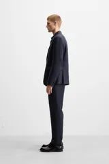 Blazer azul marino de lino, corte regular fit, con solapas de muesca, cierre de dos botones, bolsillo de vivo en el pecho, bolsillos de solapa en la cadera, aberturas en la espalda y puños con botones.