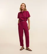 Conjunto de pantalón y camisa color fucsia. La camisa es de manga corta con cuello clásico y dos bolsillos en el pecho. El pantalón es de corte recto con cintura alta y cinturón con hebilla metálica.