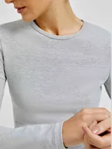 Camiseta de manga larga color gris, de corte ajustado y cuello redondo.