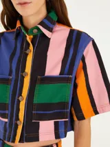Camisa cropped de sarga con estampado de rayas fantasía multicolor, cuello clásico, mangas cortas y cierre frontal con botones.