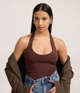 Blusa blanca de punto roma, con diseño de cuello halter que deja la espalda descubierta.