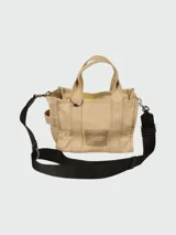 Bolso tote pequeño de lona color azul con estampado frontal de la marca en color blanco y correa de hombro negra.