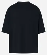 Remera negra de algodón con textura y corte oversized. Presenta estampa frontal con lettering gótico, siglas 'NY' dentro de un círculo y coordenadas geográficas.