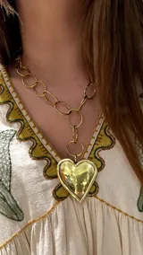 Collar dorado con cadena de eslabones grandes y dije de corazón martillado.