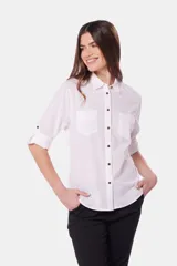 Camisa blanca de lino lisa, de manga larga con botones metálicos personalizados, dos bolsillos en el pecho y presilla en manga.