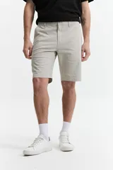 Bermuda color beige de corte chino, con presillas para cinturón y logo bordado. Confeccionada en algodón y spandex.