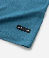 Remera deportiva de hombre color beige, manga corta, cuello redondo y corte ajustado. Presenta costuras raglán y una pequeña etiqueta en el dobladillo de la manga.