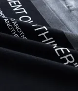 Remera negra de corte relajado con cuello redondo y manga corta. Presenta un pequeño estampado blanco en el pecho izquierdo con el texto "DEEP THOUGHTS" y un símbolo debajo.