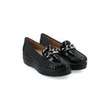 Mocasín de cuero charol negro con plataforma blanca y detalle de hebilla metálica plateada en el empeine.