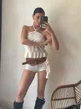 Short blanco de tiro alto con lentejuelas y cinturón marrón con tachas.