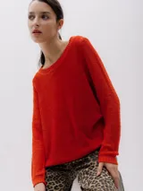 Sweater de punto color rojo ladrillo, de corte holgado y mangas largas.
