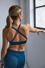 Top deportivo color verde militar con espalda cruzada en cuatro tiras y almohadillas removibles.