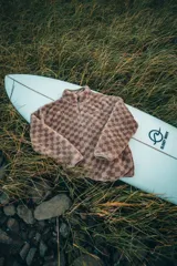 Buzo de polar con estampado a cuadros en tonos beige y marrón, con cierre parcial en el cuello y logo bordado en el pecho.