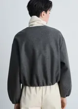 Chaqueta bomber verde oliva de lana con cierre frontal con cremallera, cuello redondo, puños y bajo elásticos.