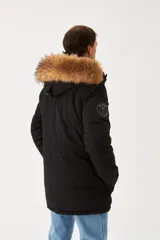 Campera Wrangler modelo Parka Henry, color negro, con capucha con borde de piel sintética, cierre frontal con cremallera y botones, múltiples bolsillos y forro acolchado.