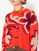 Sweater de tejido frío confeccionado en jacquard tricolor con estampado de flores. De silueta amplia y relajada, con largo a la primera cadera y mangas largas. Su calce aporta una caída fluida y contemporánea.