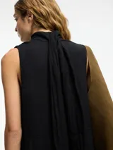 Mono negro de lino con escote en V, botones frontales, lazo ajustable en la cintura y bolsillos laterales ocultos.