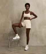 Top deportivo color marrón con breteles anchos y doble tira, copa desmontable, detalles contrastantes en color crema, escote en U delantero y escote en V en la espalda. Confeccionado en microfibra.