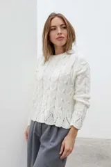 Sweater color blanco de tejido de punto calado con cuello redondo y mangas largas.
