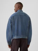Campera de jean azul con cuello clásico, cierre frontal con botones metálicos y bolsillos con solapa en el pecho.