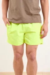 Short de baño verde flúor con cintura elástica y bolsillos laterales.
