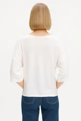 Remera negra de viscosa y elastano, manga 3/4 con botones en las mangas y cuello redondo.