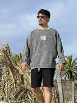 Buzo gris con efecto lavado, cuello redondo y puños acanalados. Estampado en el frente con la frase "Chema Surf Trip" y un dibujo de una camioneta combi.